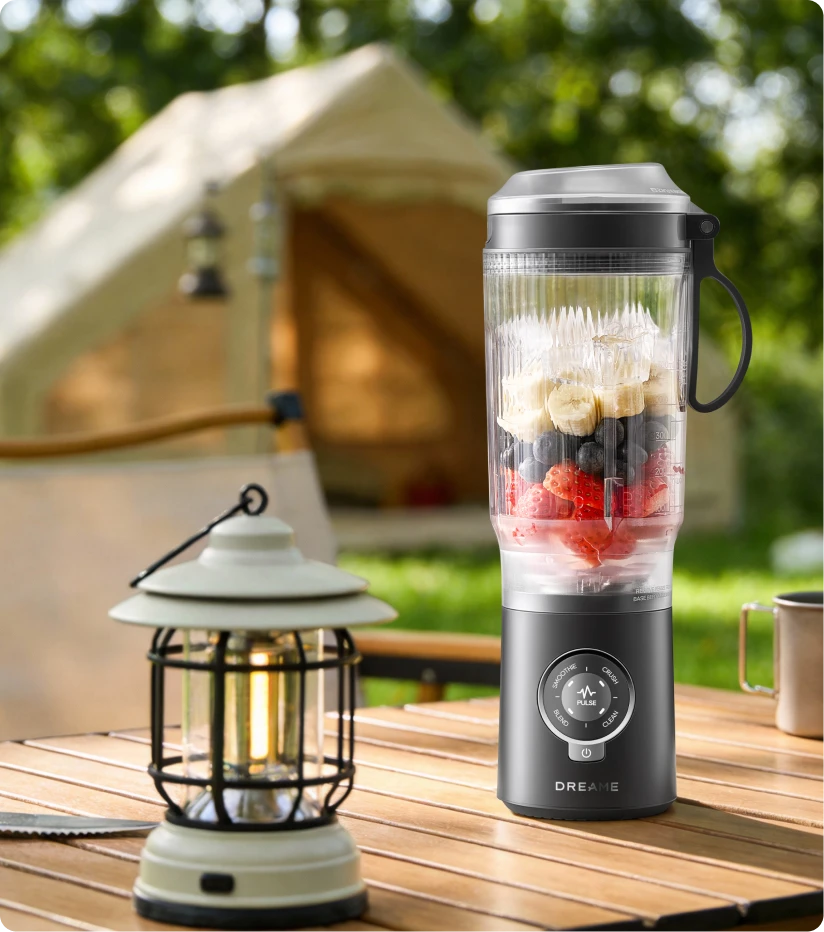 Batidora Dreame Portable Blender batiendo fruta fresca al aire libre para disfrutar en el camping