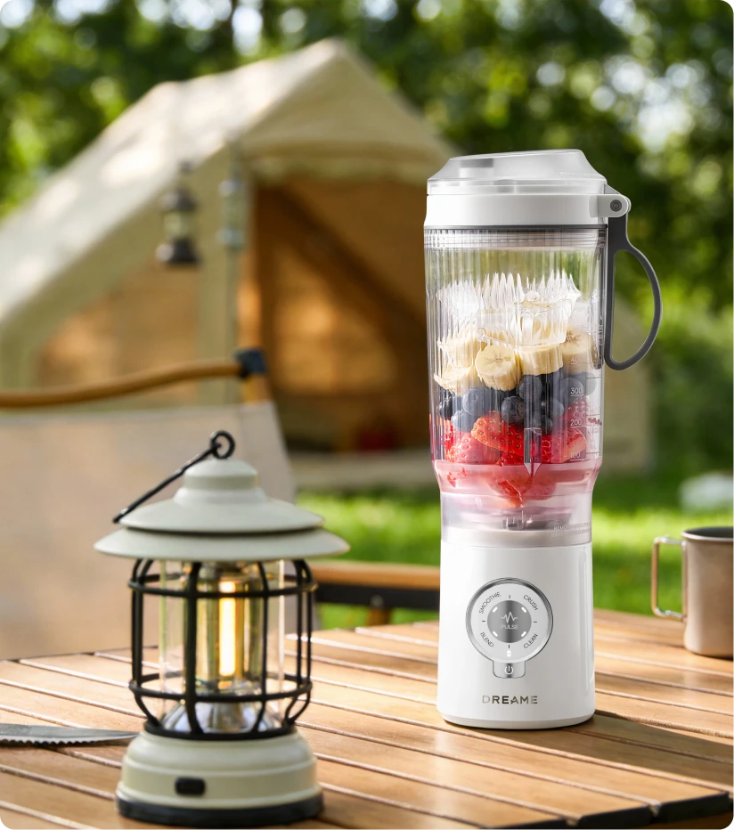 Batidora Dreame Portable Blender batiendo fruta fresca al aire libre para disfrutar en el camping