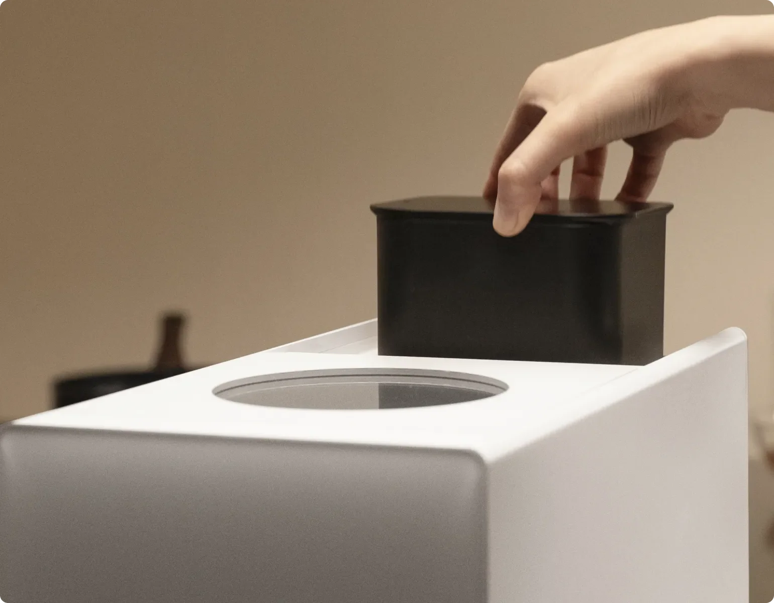 Una mano inserta el filtro de carbón activo en el Dreame SF25 WiFi, que inhibe los olores con materiales purificantes de alta calidad directamente en la fuente.